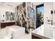 Sleek bathroom featuring a freestanding tub, a glass enclosed shower, and floor to ceiling marble feature at 6 Rockmount Ct, Henderson, NV 89012