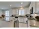 Bright kitchen featuring white cabinets, granite countertops, an island, and stainless steel appliances at 829 N Water St, Henderson, NV 89011