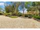 A manicured backyard with lush landscaping, trees, and a peek at the covered patio at 1629 Black Fox Canyon Rd, Henderson, NV 89052