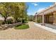 Manicured backyard with lush landscaping, trees, and covered patio at 1629 Black Fox Canyon Rd, Henderson, NV 89052
