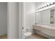 Bright bathroom featuring a white vanity, a large mirror and toilet at 1629 Black Fox Canyon Rd, Henderson, NV 89052