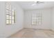 Bedroom with two windows, white walls, and carpet ready for new flooring at 1629 Black Fox Canyon Rd, Henderson, NV 89052