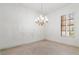 Bright formal dining room featuring neutral tile floors, white walls, shuttered windows, and a decorative chandelier at 1629 Black Fox Canyon Rd, Henderson, NV 89052