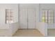 Light-filled foyer with white walls, neutral tile floors, shuttered windows and grand double doors at 1629 Black Fox Canyon Rd, Henderson, NV 89052