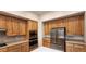 This kitchen features natural wood cabinets, a center island, and stainless steel appliances for modern cooking convenience at 1629 Black Fox Canyon Rd, Henderson, NV 89052