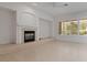 Living room featuring a tiled fireplace, neutral paint, and large windows with shutter-style blinds at 1629 Black Fox Canyon Rd, Henderson, NV 89052