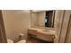 Powder room featuring a single sink vanity with a neutral colored countertop and mirror at 1629 Black Fox Canyon Rd, Henderson, NV 89052