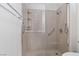 Close-up of the glass-enclosed shower with built-in shelving and grab bars at 1629 Black Fox Canyon Rd, Henderson, NV 89052