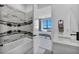 Bathroom with a sleek tub, marble accents, and a view into a bright bedroom with outside views at 9760 Solar Ave, Las Vegas, NV 89149