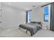 Minimalist bedroom with large windows, plush carpeting, and neutral tones for a serene atmosphere at 9760 Solar Ave, Las Vegas, NV 89149