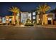 Elegant modern home featuring palm trees, stone accents, and an inviting entrance at nighttime at 9760 Solar Ave, Las Vegas, NV 89149
