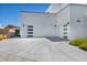 Modern home featuring a spacious driveway and two-car garage with decorative windows and xeriscaping at 9760 Solar Ave, Las Vegas, NV 89149
