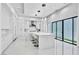 Bright, all-white kitchen features a large center island, pendant lighting, and modern appliances at 9760 Solar Ave, Las Vegas, NV 89149