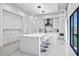 Modern kitchen features sleek white cabinetry, pendant lighting, an island, and access to outdoor space at 9760 Solar Ave, Las Vegas, NV 89149