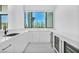 Modern kitchenette with sleek white cabinetry, wine storage, and a view of the yard at 9760 Solar Ave, Las Vegas, NV 89149
