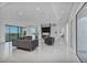 Expansive living room with sleek tile floors, modern furnishings, and floor-to-ceiling windows that reveal beautiful landscape views at 9760 Solar Ave, Las Vegas, NV 89149
