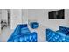 Elegant living room with stylish blue seating, tiled floors, and open access to other living spaces at 9760 Solar Ave, Las Vegas, NV 89149