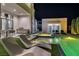 Poolside relaxation with modern loungers, an outdoor kitchen, and a well-lit pool and spa area at night at 9760 Solar Ave, Las Vegas, NV 89149