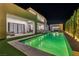 Backyard swimming pool and spa with turf surround, highlighted by sleek lounge chairs and outdoor seating at 9760 Solar Ave, Las Vegas, NV 89149