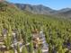 Aerial view of cabins surrounded by lush forest and majestic mountains at 2196 Via Dulcedo St, Mount Charleston, NV 89124