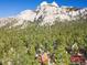Breathtaking aerial view of a charming mountain cabin nestled in a lush forest, with majestic mountains in the background at 2196 Via Dulcedo St, Mount Charleston, NV 89124