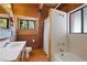 Cabin bathroom featuring a shower and bathtub combination, a toilet, a vanity with a sink, and a window with a view at 2196 Via Dulcedo St, Mount Charleston, NV 89124