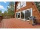 A-frame cabin with a spacious outdoor deck and barbecue grill surrounded by lush greenery and a charming sun decoration at 2196 Via Dulcedo St, Mount Charleston, NV 89124