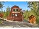 Cabin-style home with a wooden deck, nestled among lush greenery and includes a storage shed at 2196 Via Dulcedo St, Mount Charleston, NV 89124