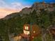 Charming cabin-style home with mountain views and a wooden deck, nestled among lush greenery at 2196 Via Dulcedo St, Mount Charleston, NV 89124