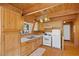 Cabin kitchen with wood cabinets, white appliances, and wood ceiling at 2196 Via Dulcedo St, Mount Charleston, NV 89124