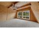 Bright loft featuring wood walls, carpet, fan, and scenic views through large windows at 2196 Via Dulcedo St, Mount Charleston, NV 89124