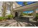 Covered driveway leading to an elegant front entrance, complemented by mature landscaping at 2349 Villandry Ct, Henderson, NV 89074