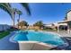 Large in-ground pool and spa surrounded by lush turf, palm trees, and a covered patio area at 4474 Dawley Ct, Las Vegas, NV 89104