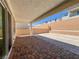 Covered backyard patio, with brick pavers, and landscaped retaining wall at 9009 Shifting Skye St, Las Vegas, NV 89166