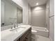 Well-lit bathroom featuring a shower-tub combination and a modern vanity with a white countertop at 9009 Shifting Skye St, Las Vegas, NV 89166