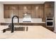 Close-up of a modern kitchen with a large island, gas cooktop, and double ovens at 9009 Shifting Skye St, Las Vegas, NV 89166