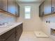 Laundry room with cabinets, countertop, sink, tile floor, and utility hookups at 9009 Shifting Skye St, Las Vegas, NV 89166