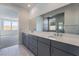 Double sink bathroom with gray cabinets and a large mirror at 9068 Cielo Canyon St, Las Vegas, NV 89166