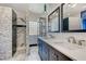 Bathroom with double vanity, marble shower, and glass block window at 1150 Calcione Dr, Henderson, NV 89011