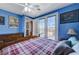 Blue bedroom with wood bed frame and access to private deck at 1150 Calcione Dr, Henderson, NV 89011