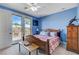 Blue bedroom with wood bed frame and access to private deck at 1150 Calcione Dr, Henderson, NV 89011