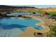 Outdoor community pool with lounge seating, landscaping, and shade umbrellas overlooking the golf course at 977 Majestic Vw, Mesquite, NV 89034