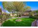 Beautiful backyard featuring a putting green, lush landscaping, and a pergola at 17 Winding Rd, Henderson, NV 89052
