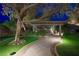 Night view of a backyard showcasing a putting green, seating area, pergola, and lighting at 17 Winding Rd, Henderson, NV 89052