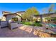 Outdoor kitchen and pool area featuring custom pergola and brick pathway at 17 Winding Rd, Henderson, NV 89052