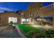 A backyard patio at night offers pavers, seating, lush landscaping and romantic soft lighting throughout the space at 17 Winding Rd, Henderson, NV 89052