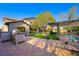 Outdoor kitchen and seating area overlook the lush backyard with a pool and landscaping at 17 Winding Rd, Henderson, NV 89052