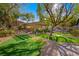 Beautiful backyard with mature trees, putting green, and covered seating area at 17 Winding Rd, Henderson, NV 89052