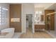 A modern bathroom features a soaking tub, walk-in shower, and access to a walk-in closet at 17 Winding Rd, Henderson, NV 89052