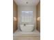 Elegant bathroom with stylish soaking tub situated in front of decorative window at 17 Winding Rd, Henderson, NV 89052